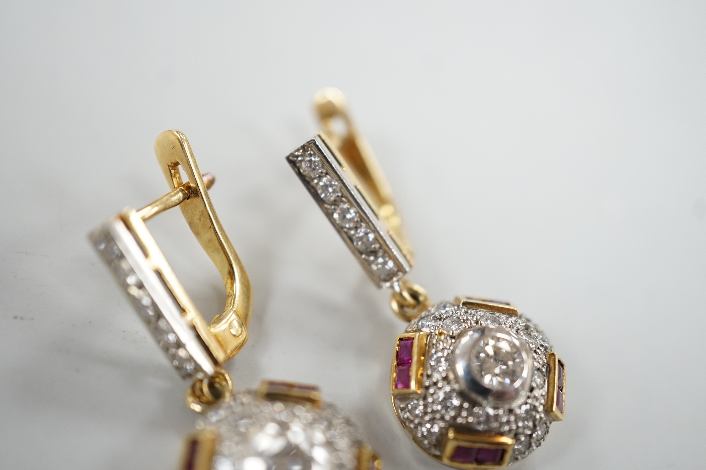 A modern pair of yellow metal, square cut ruby and round cut diamond set circular cluster drop earrings, 30mm, gross weight 8.4 grams.
